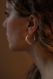 detail of a models ear wearing Silver hoops with graphic details reminiscent of lace