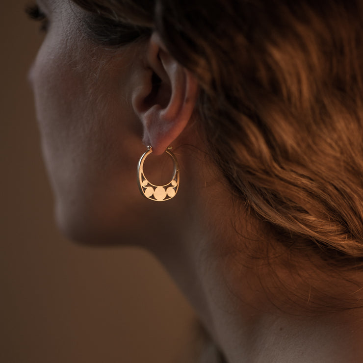 Detail of Gold hoops on a model. 14K Gold hoops with graphic details reminiscent of lace. These Earrings are made of Fairmined Gold, extracted from Fair trade mines in Colombia and Peru.