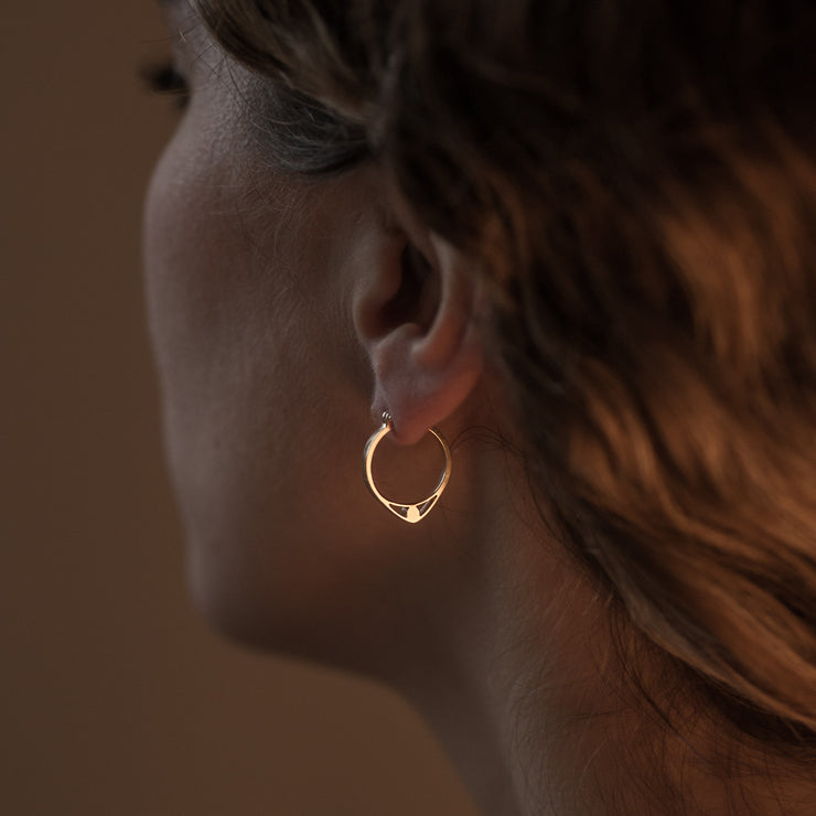 Detail of Gold hoops on a model. 14K Gold hoops with graphic details reminiscent of lace. These Earrings are made of Fairmined Gold, extracted from Fair trade mines in Colombia and Peru.