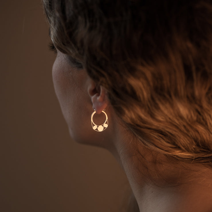 Detail of Gold hoops on a model. 14K Gold hoops with graphic details reminiscent of lace. These Earrings are made of Fairmined Gold, extracted from Fair trade mines in Colombia and Peru.