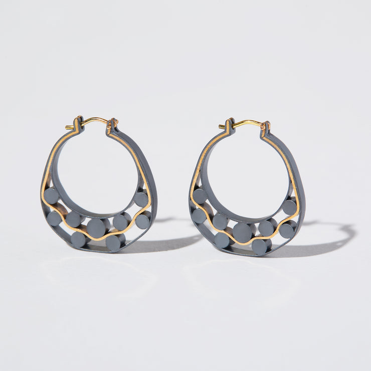 Detail of Gold hoops on a model. 14K Gold hoops with graphic details reminiscent of lace. These Earrings are made of Fairmined Gold, extracted from Fair trade mines in Colombia and Peru.