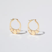 Detail of Gold hoops on a model. 14K Gold hoops with graphic details reminiscent of lace. These Earrings are made of Fairmined Gold, extracted from Fair trade mines in Colombia and Peru.