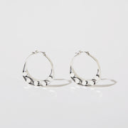 Silver hoops with graphic details reminiscent of lace