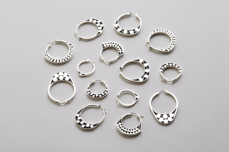 Silver hoops with graphic details reminiscent of lace