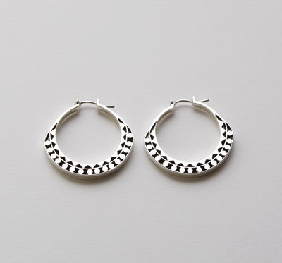 Silver hoops with graphic details reminiscent of lace