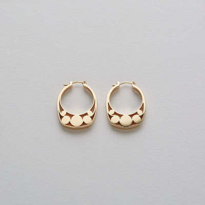 Detail of Gold hoops on a model. 14K Gold hoops with graphic details reminiscent of lace. These Earrings are made of Fairmined Gold, extracted from Fair trade mines in Colombia and Peru.