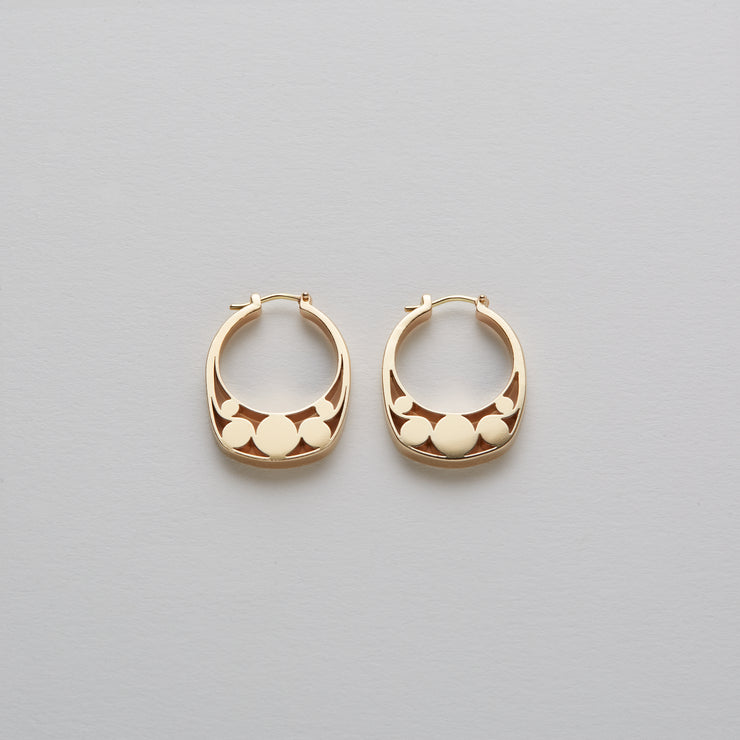 Detail of Gold hoops on a model. 14K Gold hoops with graphic details reminiscent of lace. These Earrings are made of Fairmined Gold, extracted from Fair trade mines in Colombia and Peru.