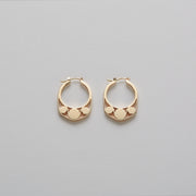 Detail of Gold hoops on a model. 14K Gold hoops with graphic details reminiscent of lace. These Earrings are made of Fairmined Gold, extracted from Fair trade mines in Colombia and Peru.