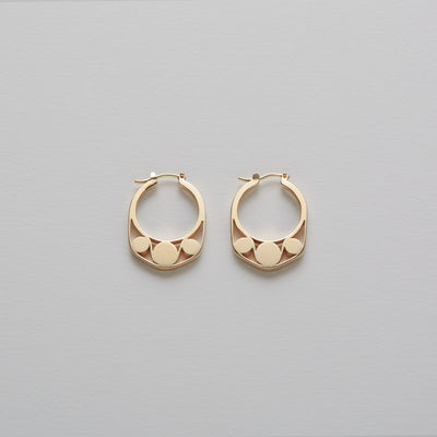 Detail of Gold hoops on a model. 14K Gold hoops with graphic details reminiscent of lace. These Earrings are made of Fairmined Gold, extracted from Fair trade mines in Colombia and Peru.