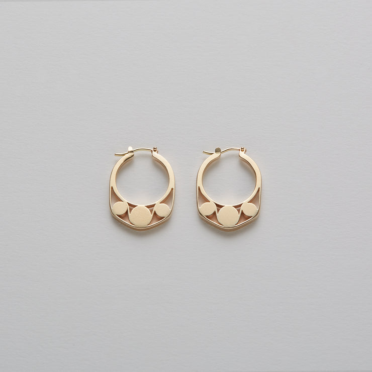 Detail of Gold hoops on a model. 14K Gold hoops with graphic details reminiscent of lace. These Earrings are made of Fairmined Gold, extracted from Fair trade mines in Colombia and Peru.