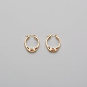 Detail of Gold hoops on a model. 14K Gold hoops with graphic details reminiscent of lace. These Earrings are made of Fairmined Gold, extracted from Fair trade mines in Colombia and Peru.