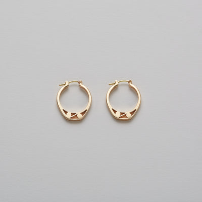 Detail of Gold hoops on a model. 14K Gold hoops with graphic details reminiscent of lace. These Earrings are made of Fairmined Gold, extracted from Fair trade mines in Colombia and Peru.