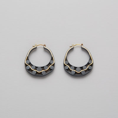 Detail of Gold hoops on a model. 14K Gold hoops with graphic details reminiscent of lace. These Earrings are made of Fairmined Gold, extracted from Fair trade mines in Colombia and Peru.