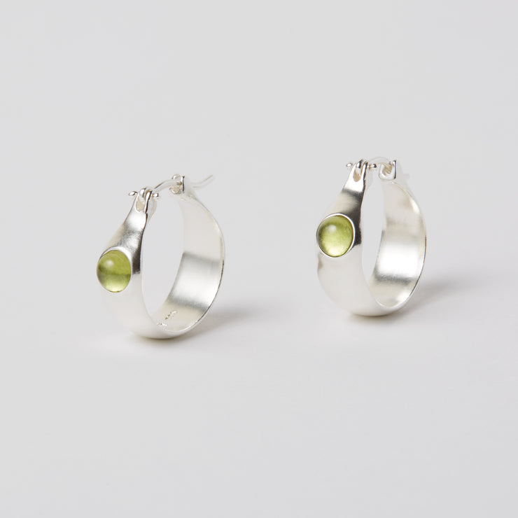 The Gem Hoops is an everyday hoop, with a hint of color added by the semiprecious gem. The earrings come in sterling silver or brass and have a hinged ear wire made of sterling silver. They measure about 3/4 of an inch diameter and are now available as singles so different gem stones can be paired together.   The semi precious gems sit in the front of the earrings come in Amber, Amethyst, Chalcedony, Citrine and Green Onyx and Peridot. available at suna bonometti dot come 