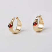 The Gem Hoops is an everyday hoop, with a hint of color added by the semiprecious gem. The earrings come in sterling silver or brass and have a hinged ear wire made of sterling silver. They measure about 3/4 of an inch diameter and are now available as singles so different gem stones can be paired together.   The semi precious gems sit in the front of the earrings come in Amber, Amethyst, Chalcedony, Citrine and Green Onyx and Peridot. Available at Suna Bonometti dot come