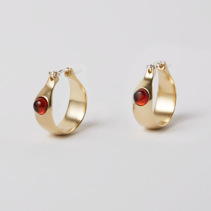 The Gem Hoops is an everyday hoop, with a hint of color added by the semiprecious gem. The earrings come in sterling silver or brass and have a hinged ear wire made of sterling silver. They measure about 3/4 of an inch diameter and are now available as singles so different gem stones can be paired together.   The semi precious gems sit in the front of the earrings come in Amber, Amethyst, Chalcedony, Citrine and Green Onyx and Peridot. Available at Suna Bonometti dot come